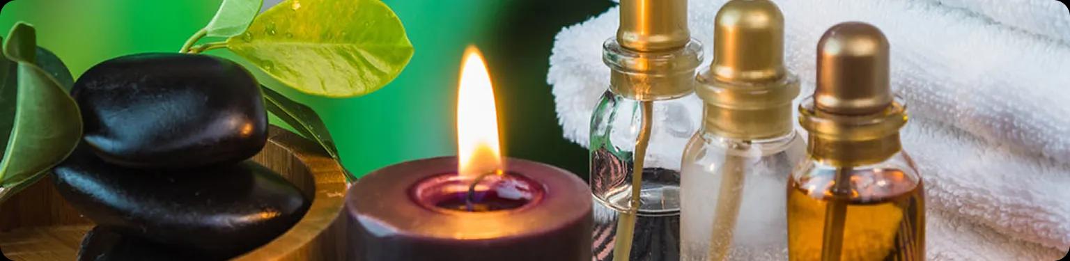 Wellness products including massage stones, candle, and therapeutic oils